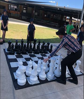 Students playing giant chess game